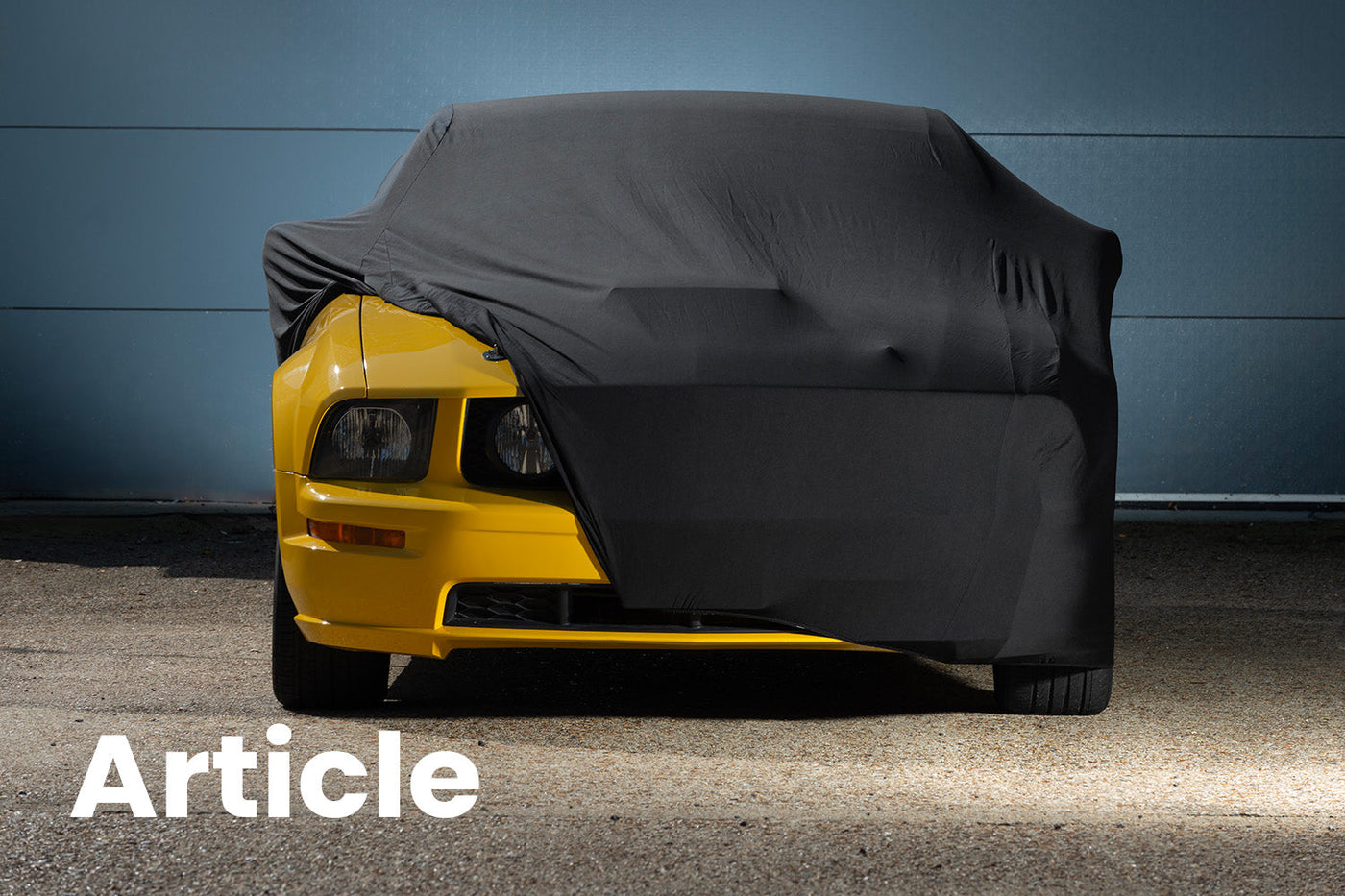 Yellow Ford Mustang With a black Indoor Car Cover over the top 