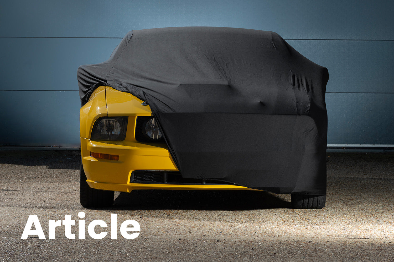Yellow Ford Mustang With a black Indoor Car Cover over the top 