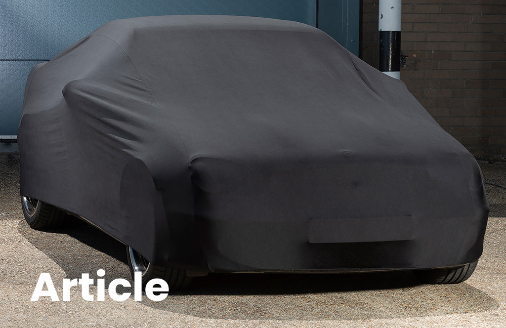 Mercedes SLK200 outside with a black indoor stretch car cover over the top 