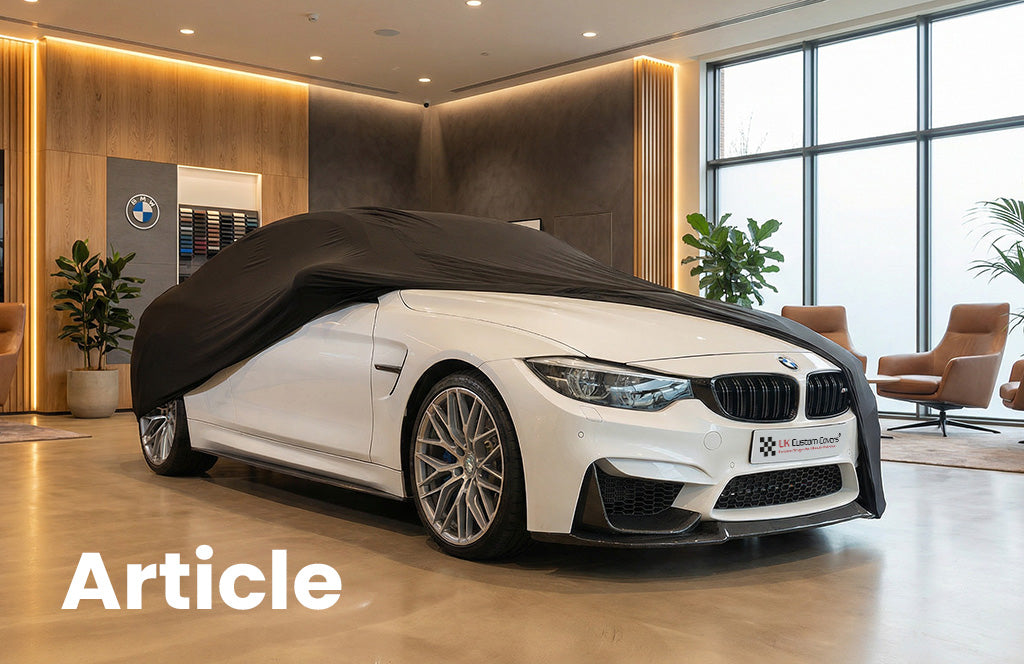 White BMW in a show room with a black indoor car cover showing the front of the car 