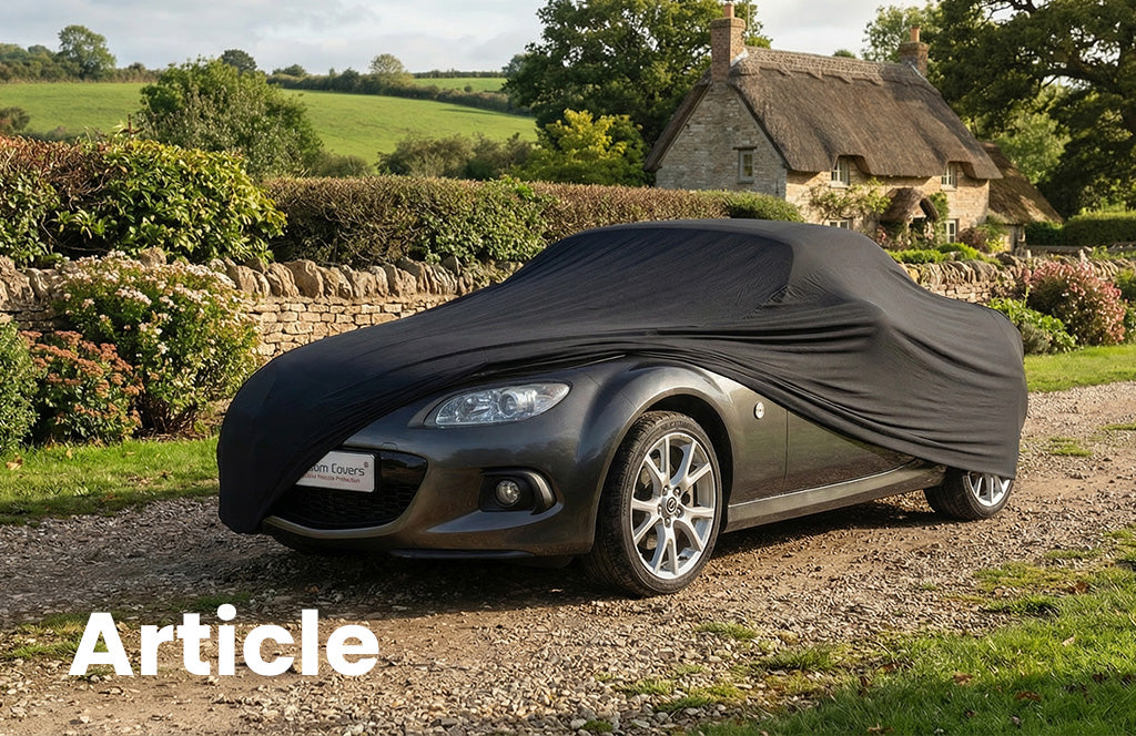 Mazda MX 5 with a black indoor car cover over the top showing the front of the vehicle