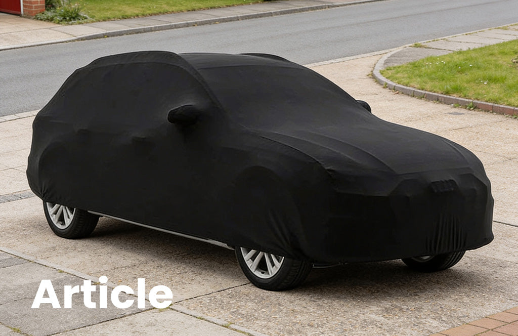 Audi A4 with a black indoor car cover over the top on a driveway 