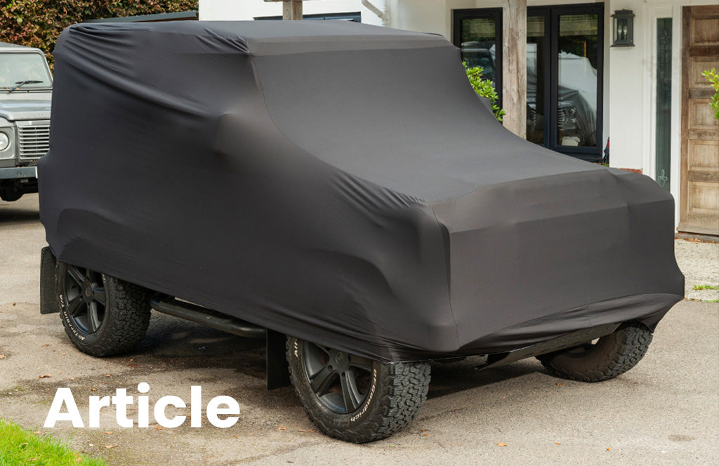 Land Rover Discovery with a indoor black car cover over the top 