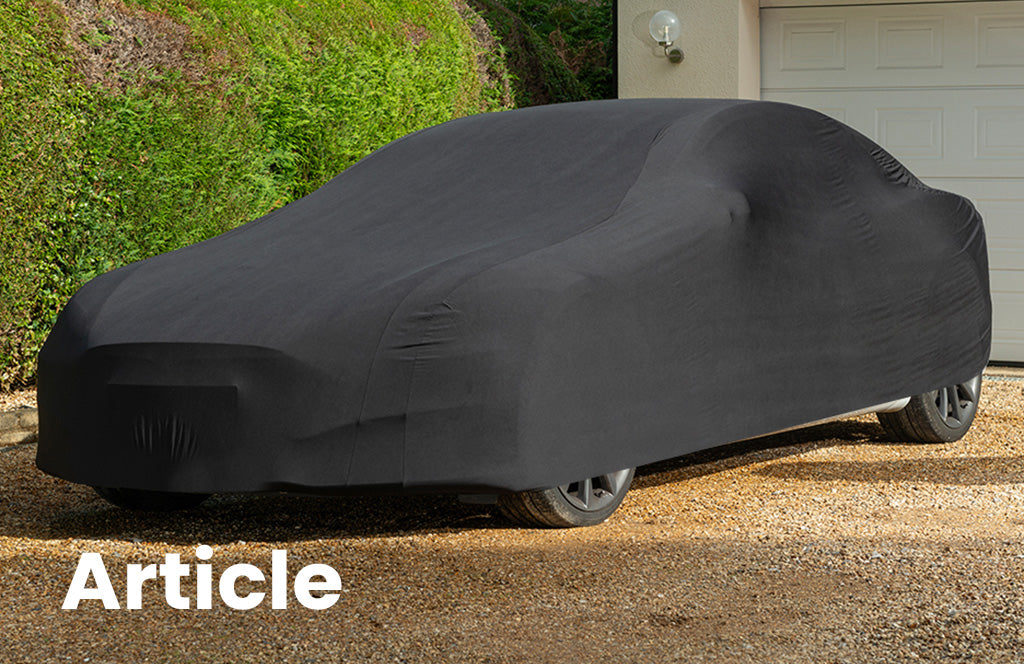 Tesla with a black indoor car cover over the top showing the curves of the car 